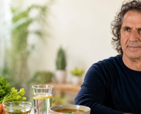 René Gräber mit Gemüsebrühe, Tee und frischen Zutaten zum veganen Heilfasten.